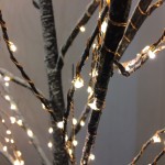 An image of a tree lit up with lights at a popular festive activity.