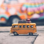 An image of a toy coach with pieces of toy luggage on strapped to the roof.