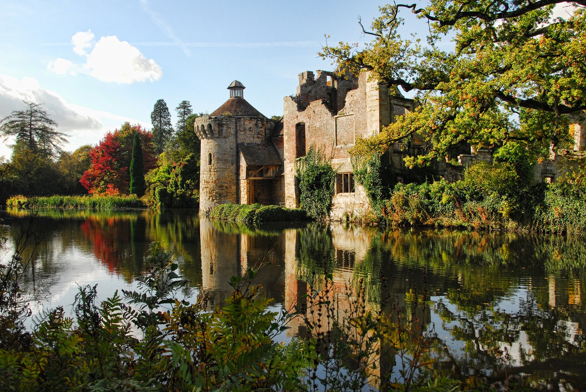 An image of Scotney castle in Kent by the waterside.